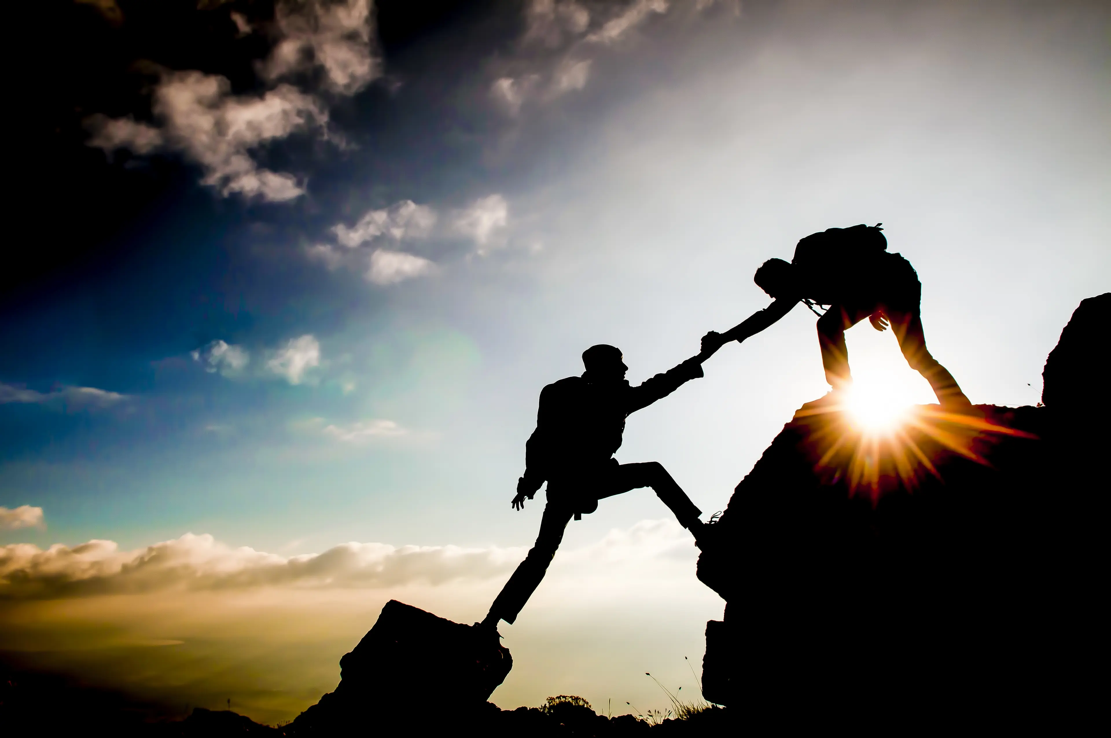 A climber reaching to another climber for help